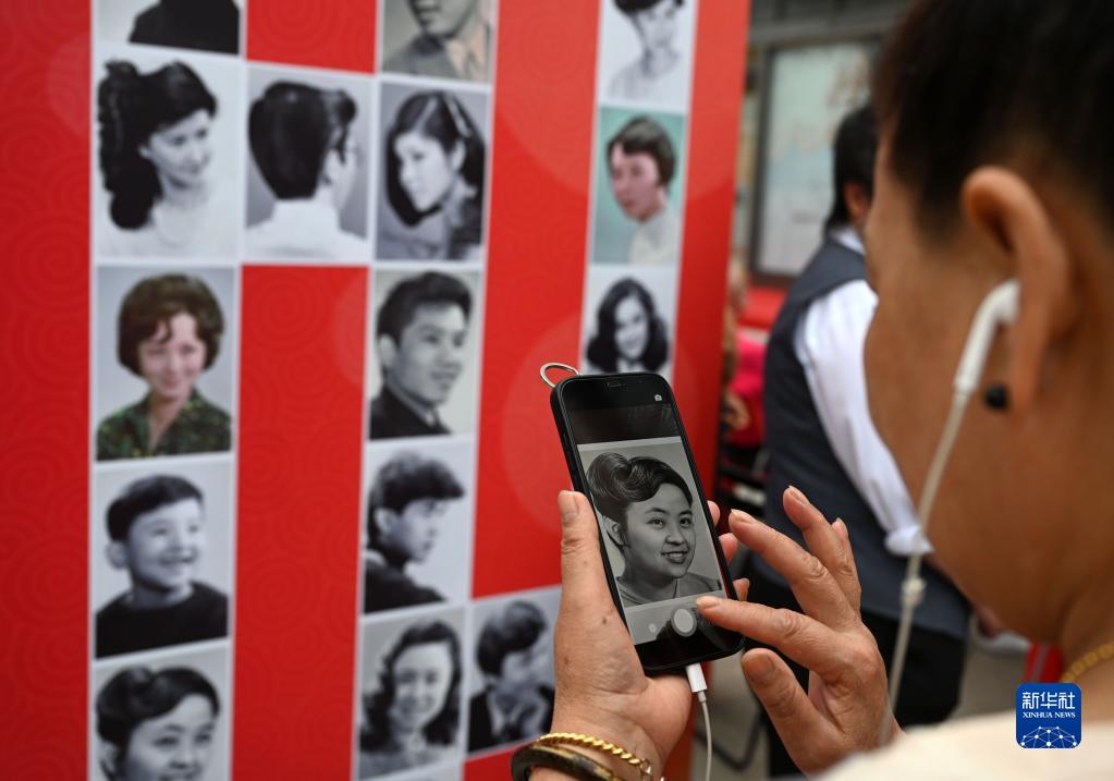 7月27日、1980年代に流行した髪型の写真を見る市民（撮影・金良快）。