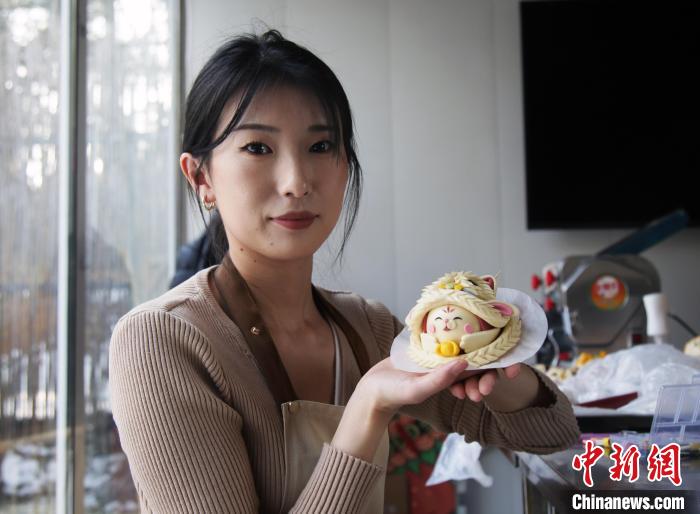 臧釵瑗さんと彼女が制作した花餑餑「醒獅兎」（撮影・孫睿姣）。
